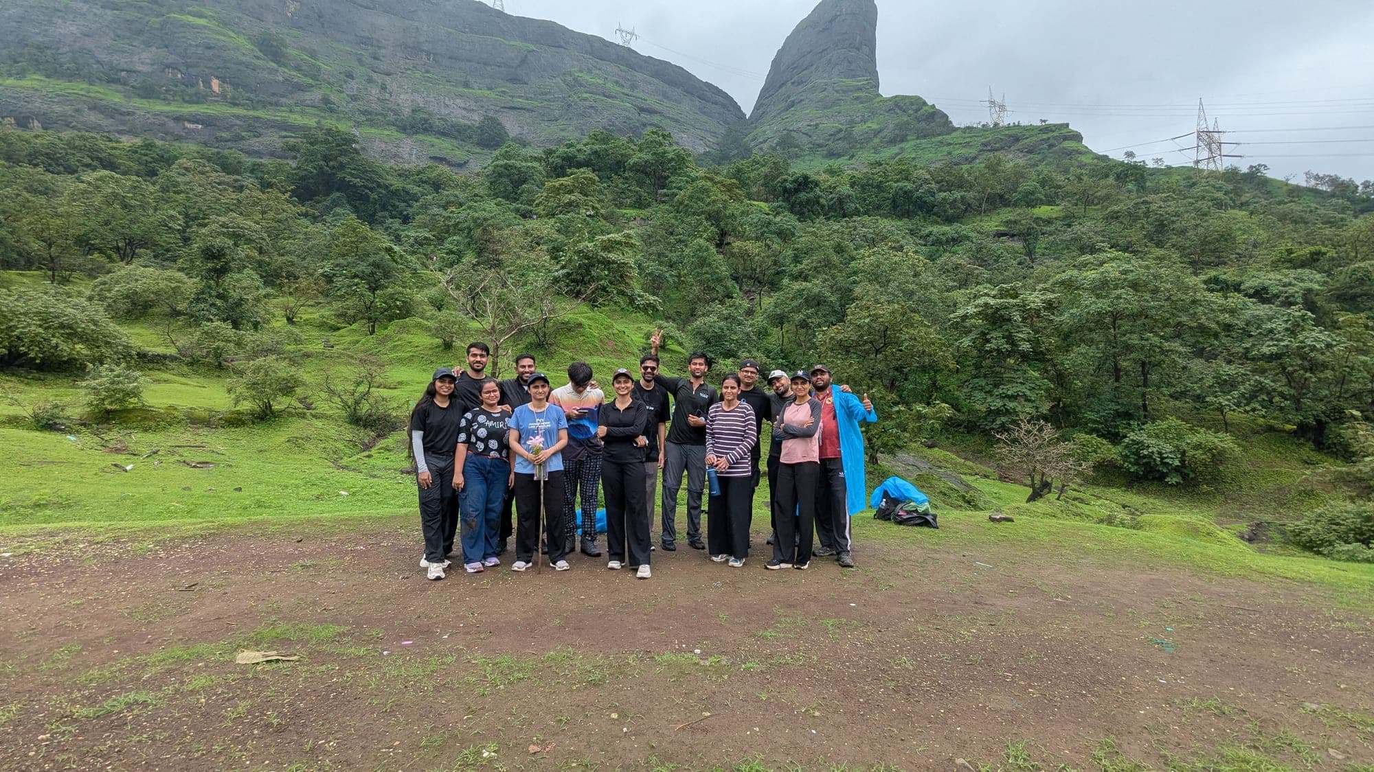 Sixteen trekkers at the base of Naneghat with the Nanacha Angtha pinnacle behind